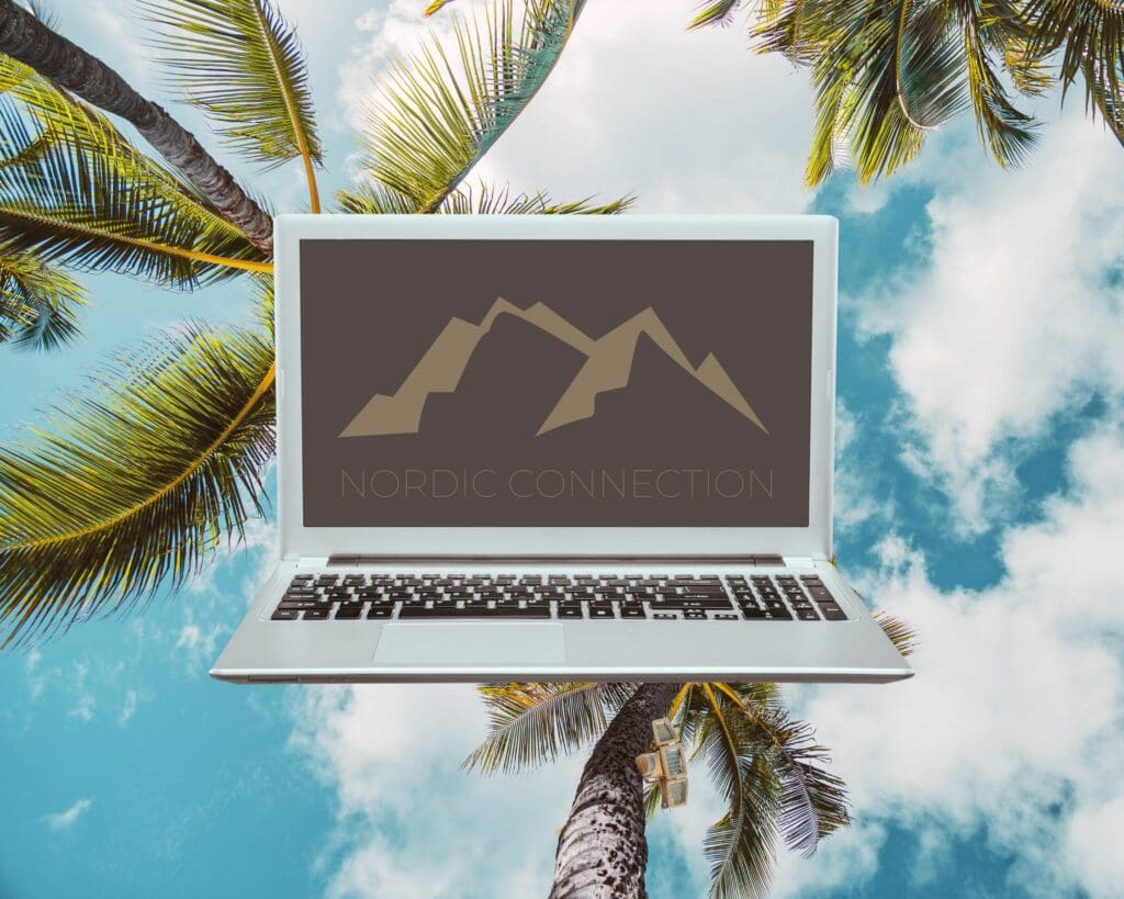 Laptop på bord ved stranden på Gran Canaria med palmer og moderne kontorutsikt i bakgrunnen, som representerer fjernarbeid kombinert med ferie.